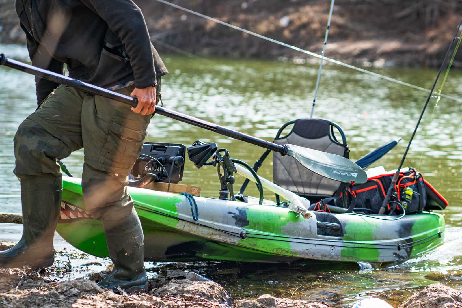 A kayak paddle, life jacket and gear laid out on a dock
