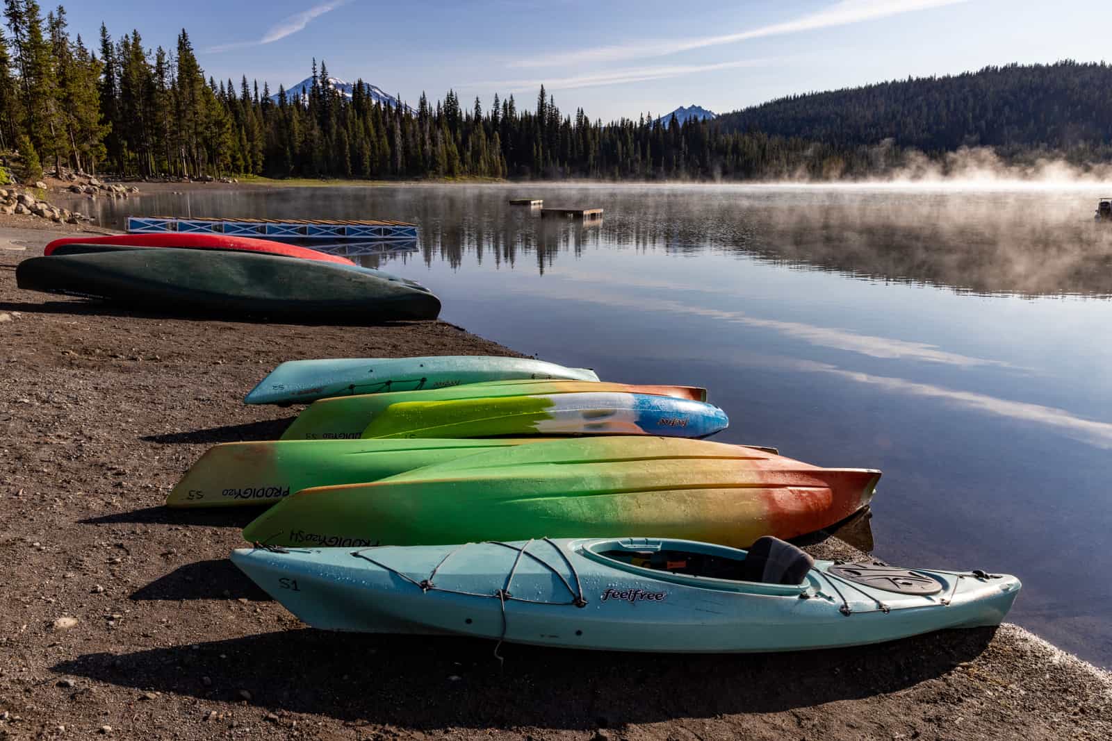 Kayaks loaded on a car roof rack at a trailhead