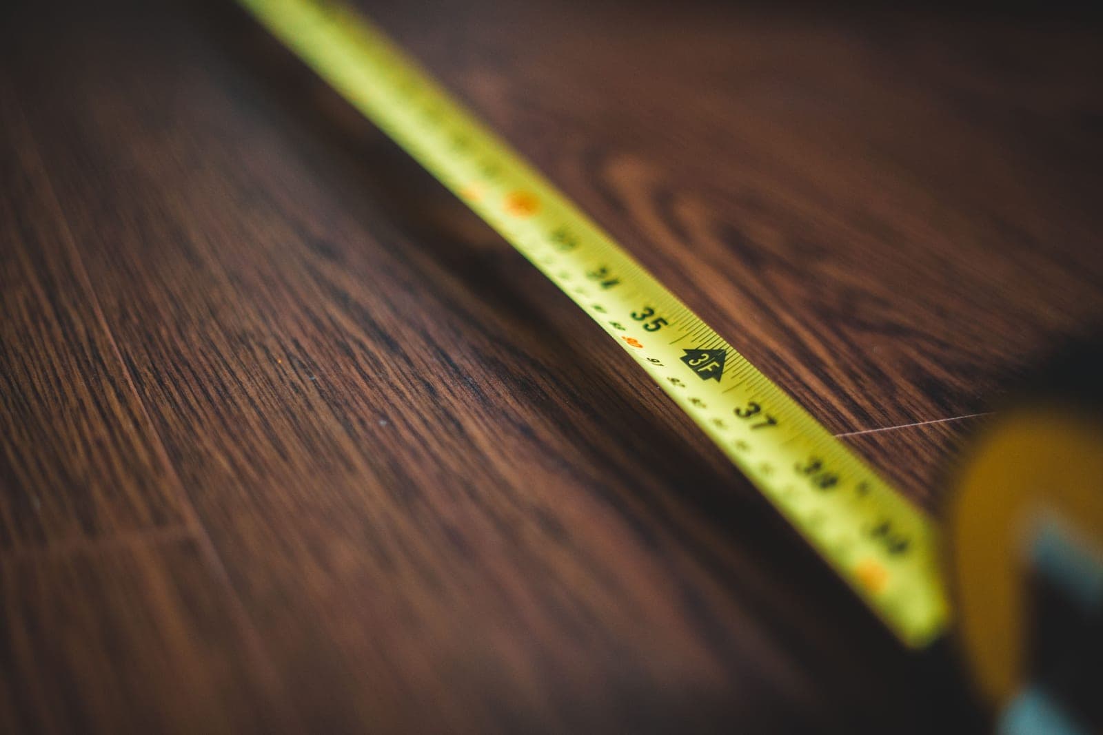 A tape measure and paddle laid on a wooden dock
