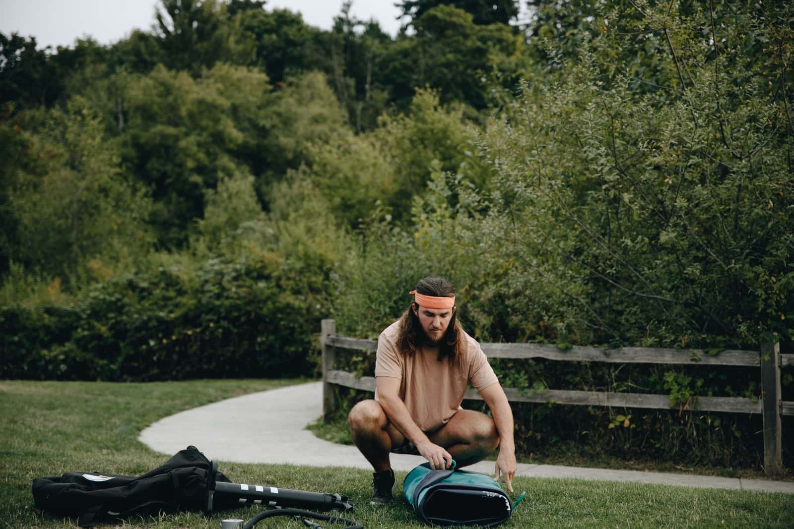 A pump inflating a paddle board on the shore