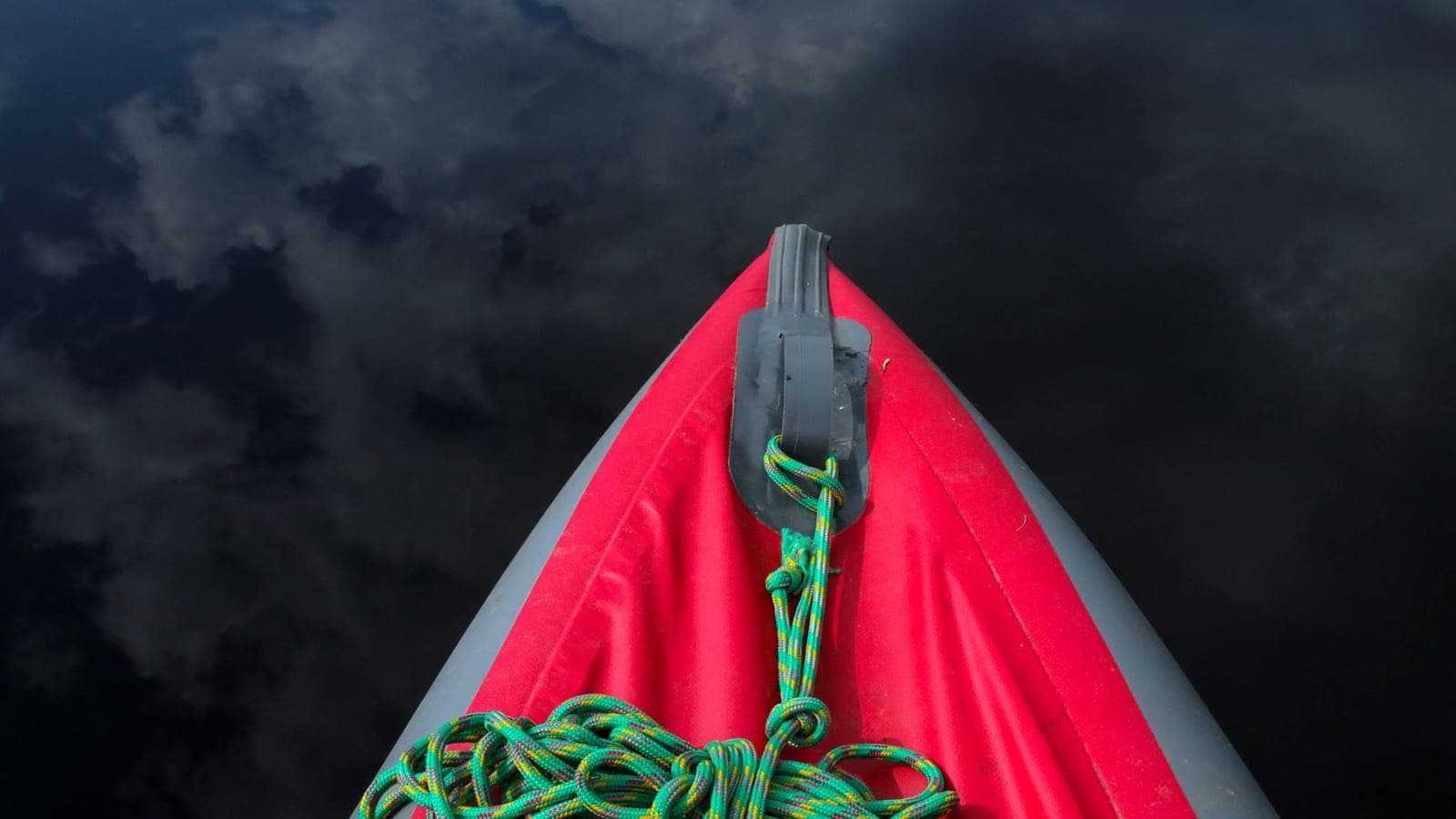 A top-down view of a kayak deck and deck line on calm water