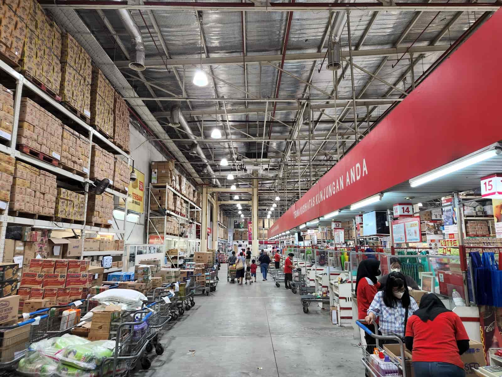 A warehouse store aisle with a shopping cart
