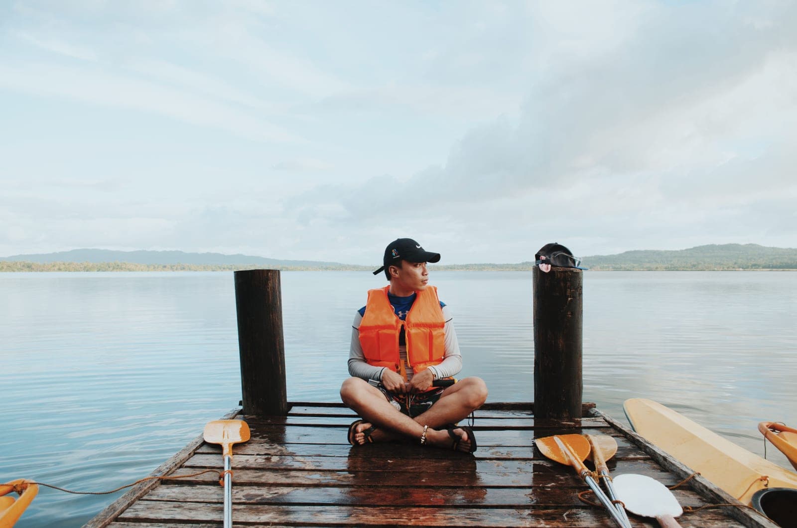 A person sitting in a kayak at a dock preparing to launch