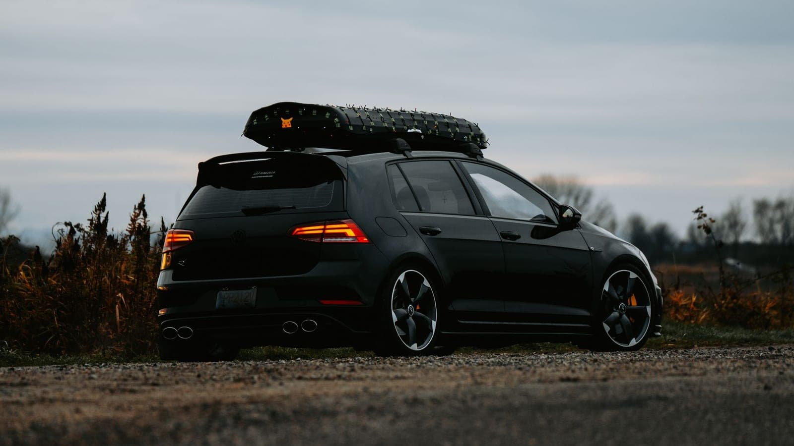 A compact hatchback with roof storage parked outdoors at dusk
