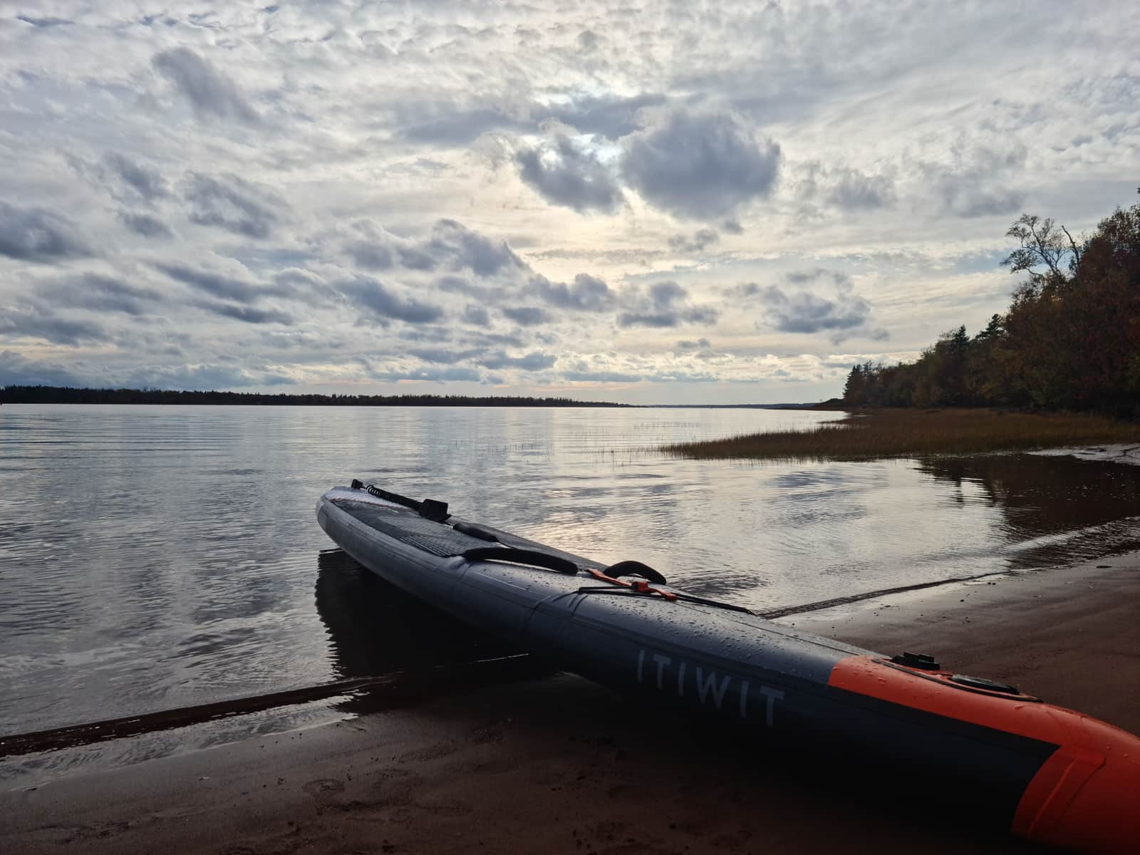 An inflatable kayak on calm lake water