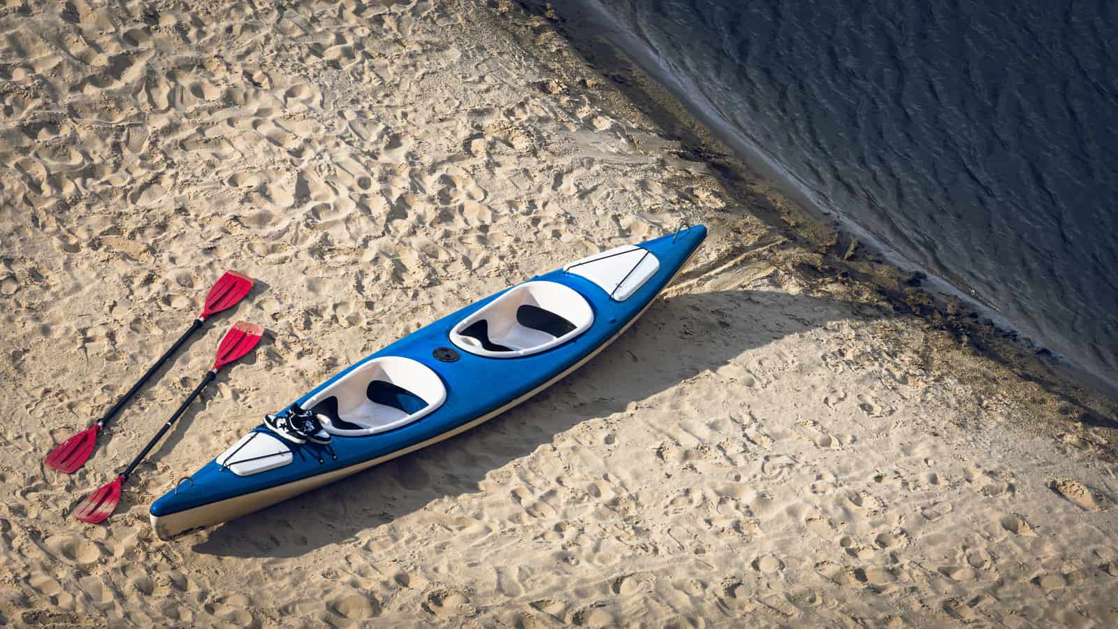 Two recreational kayaks side by side on a beach