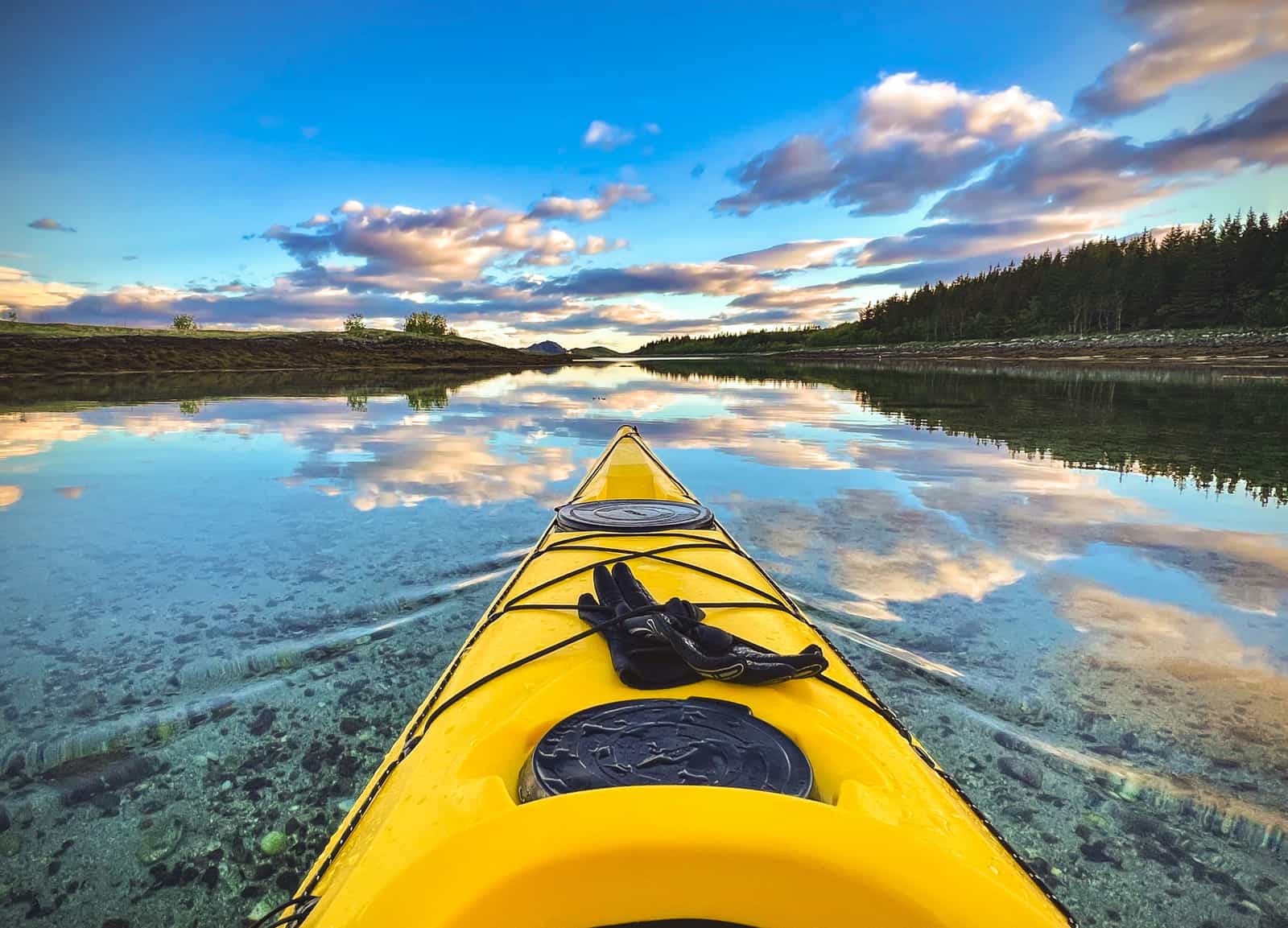 The bow of a kayak on calm water seen from the cockpit