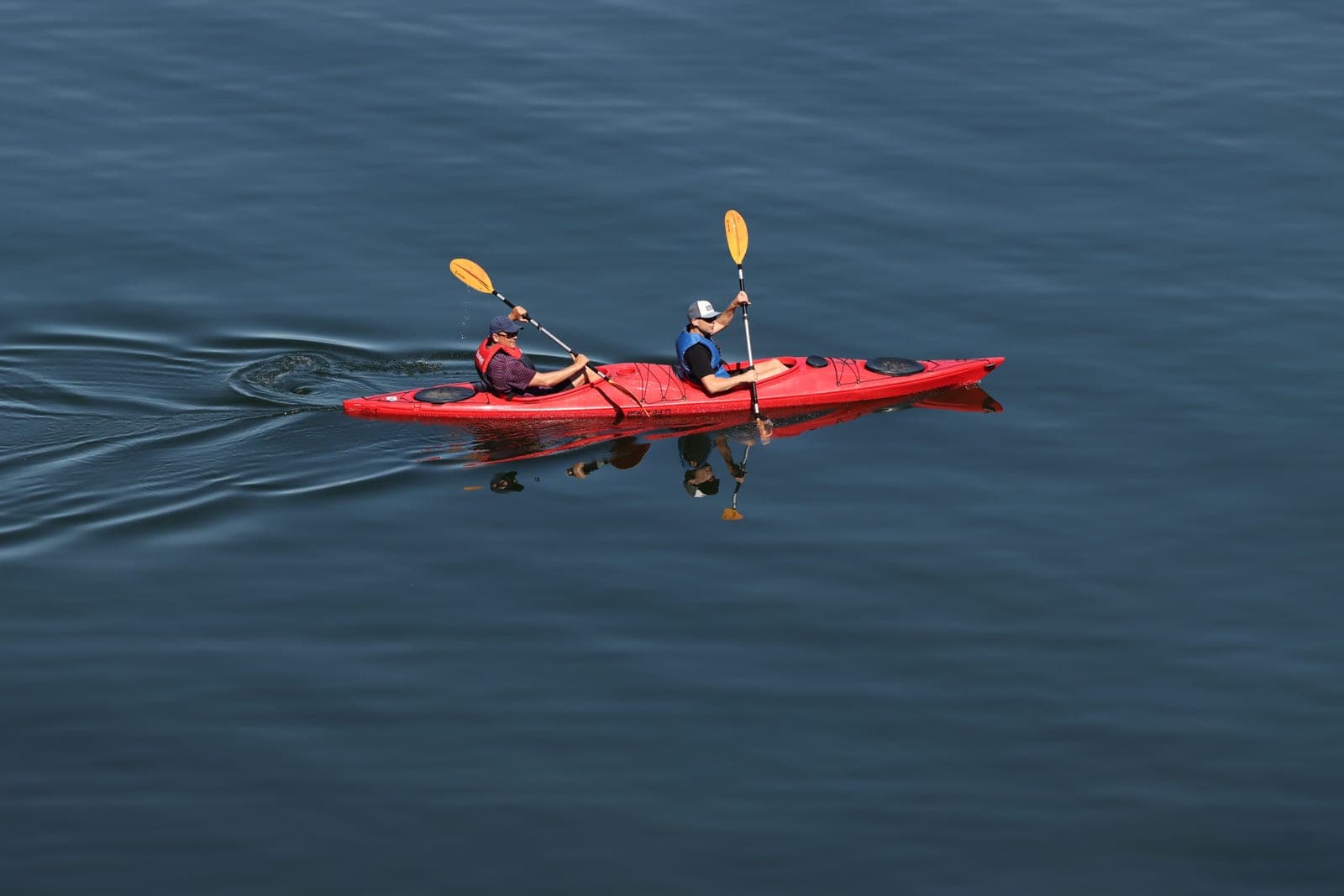 A two-person tandem kayak on a calm lake