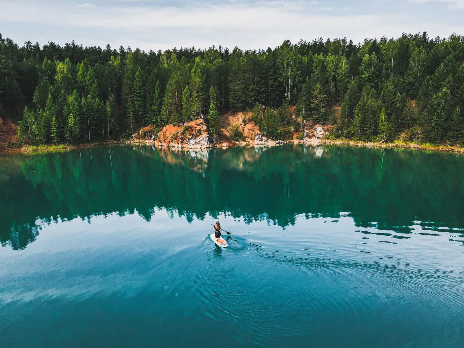 An inflatable stand up paddle board on flat, calm water in early light