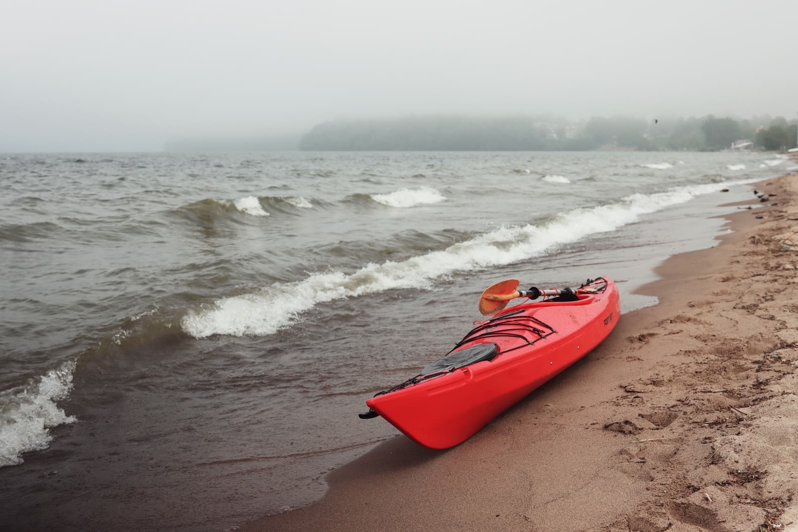 An fall lake with a kayak at the shoreline