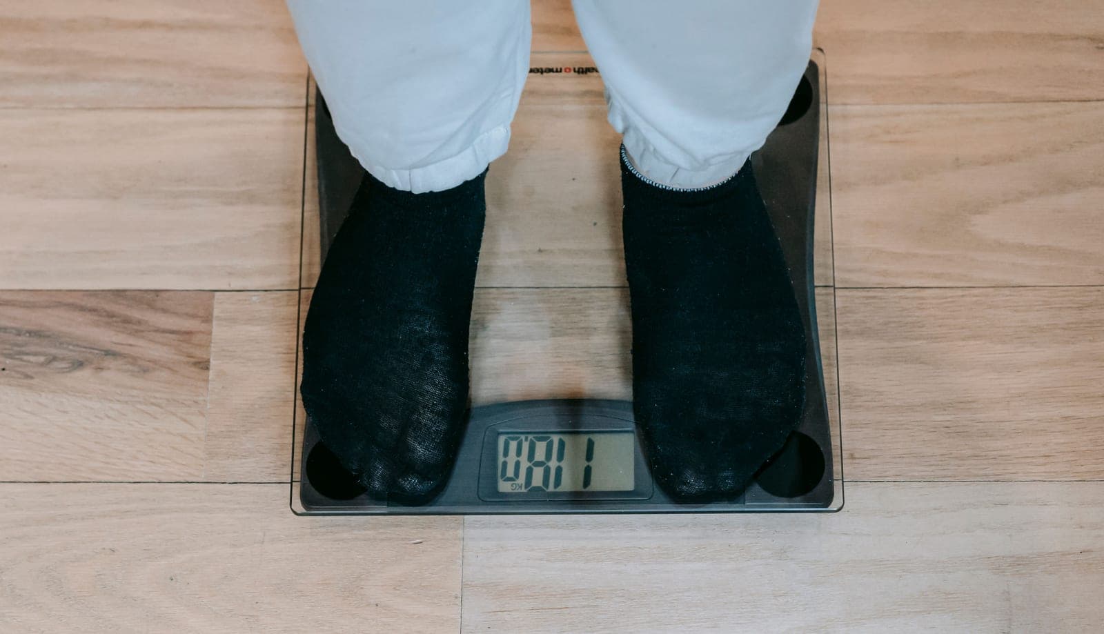 A set of scales and gear weighed on a wooden floor