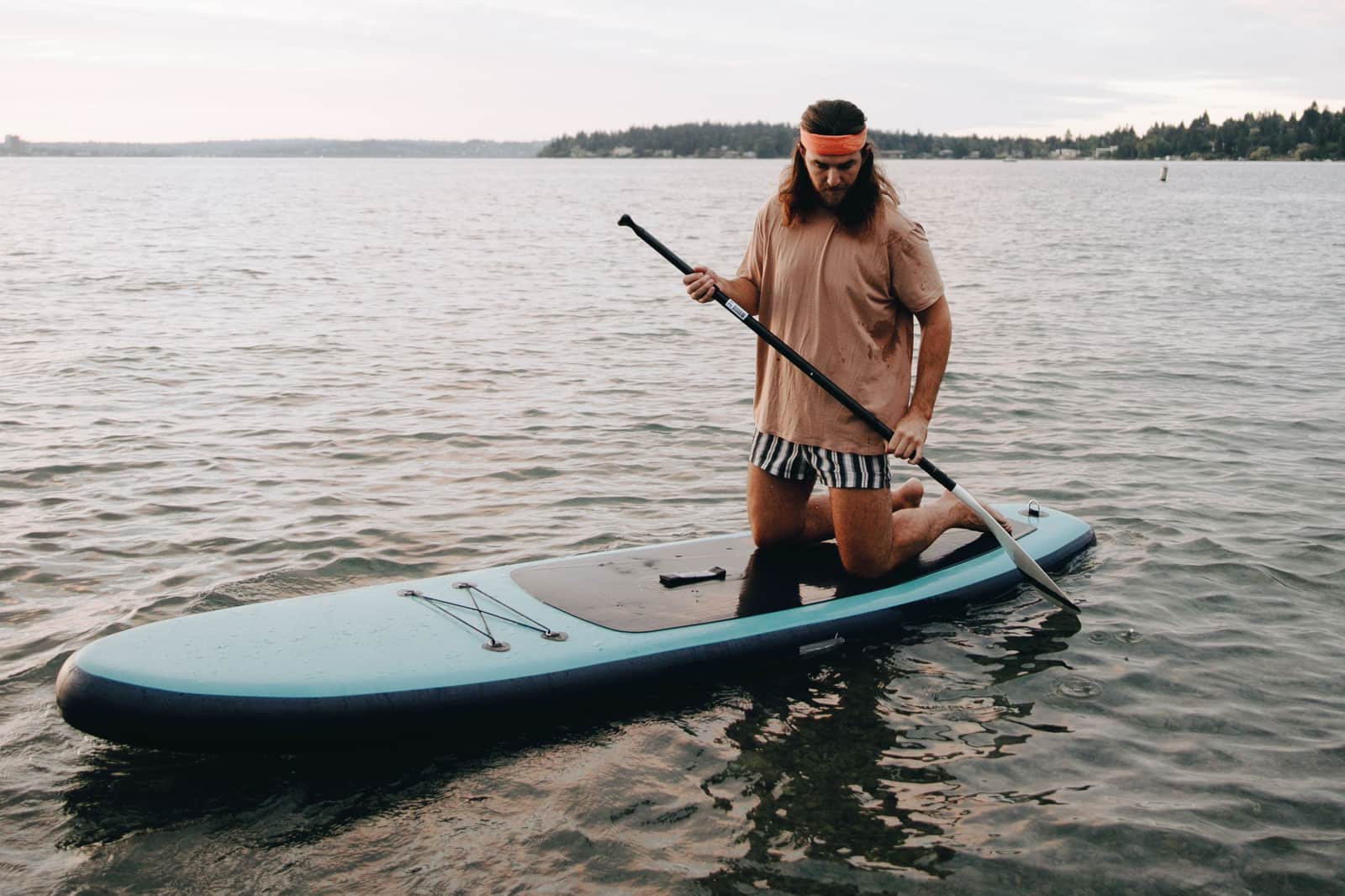 A wide, stable paddle board on a calm lake